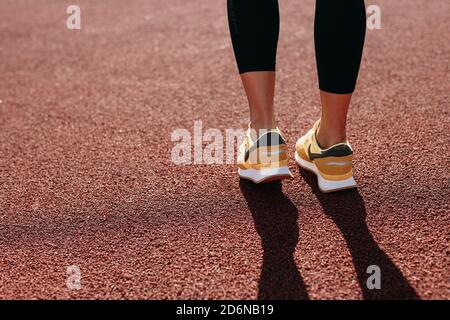 Rückansicht der Frau in den Sport-Sneakers, die bei Rot steht gericht Stockfoto