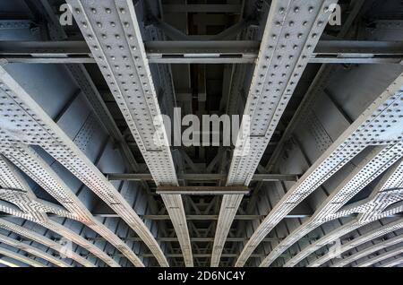 Unter der Blackfriars Railway Bridge und dem Bahnhof in London, Großbritannien. Die starken Stahlträger mit Nieten unter der Brücke halten die Struktur an ihrem Platz. Stockfoto