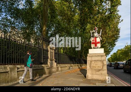 Grenzmarkierung der City of London am Victoria Embankment. Das Denkmal zeigt die City of London Dragon. Ein Fußgänger mit leichter Bewegungsunschärfe. Stockfoto