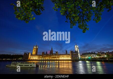 Houses of Parliament in Westminster, London, Großbritannien. Blick über die Themse mit Westminster Bridge. Boot im Vordergrund und Bewegungsunschärfe bei langer Belichtung. Stockfoto