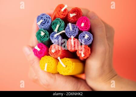 Handgemachte bunte Kerzen von Honig Chakra aus Naturwachs close up in weiblichen Händen. Weihnachts- oder Neujahrskompositionen. Foto für Postkarten. Stockfoto