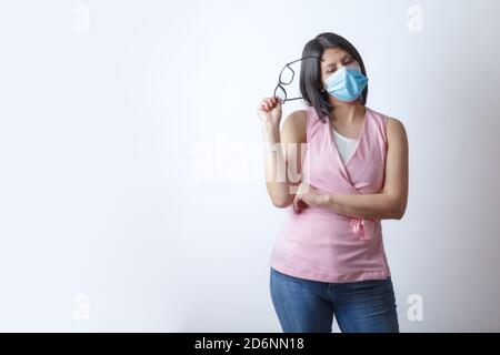 Latino Frau trägt eine medizinische Maske und Brillen posiert in Das Studio Stockfoto