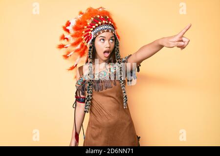 Junge schöne lateinische Mädchen trägt indische Kostüm zeigt mit Finger überrascht voraus, offenen Mund erstaunt Ausdruck, etwas auf der Vorderseite Stockfoto