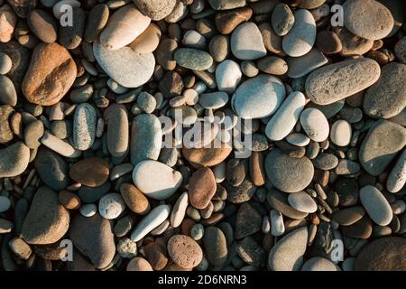 Steinkiesel am Strand als Hintergrund Stockfoto