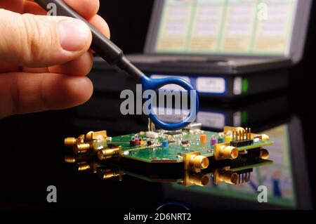 Ingenieur für elektromagnetische Verträglichkeit (EMV), der die magnetische Nahfeldsonde für hält EMV-Fehlersuche und -Messungen Stockfoto