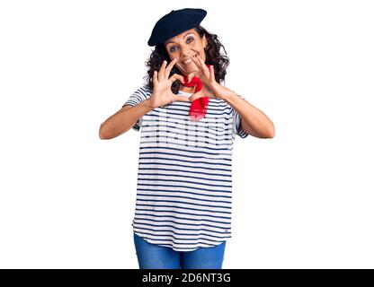 Mittelalter schöne Frau trägt französisch Baskenmütze und Schal lächelnd in der Liebe zeigt Herz Symbol und Form mit Händen. Romantisches Konzept. Stockfoto