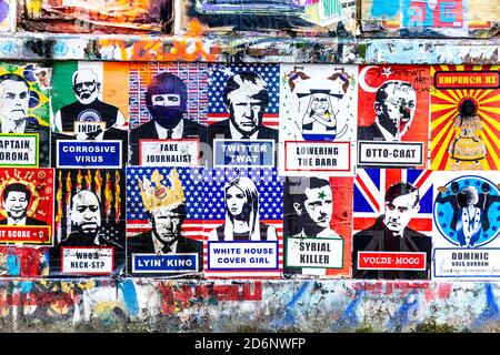 Politische Plakate an einer mit Graffiti bedeckten Wand, Plakate und Kunstwerke von Brick Lane, East London, Großbritannien Stockfoto
