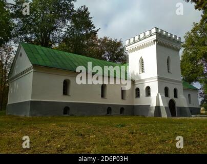 Kamenitsa Lizogubow, Ukraine. Ein altes Ziegelgebäude mit einem Turm, Steinmauern mit Fenstern, ein Schloss auf einem grünen Hügel. Stockfoto