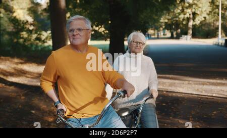 Ältere Ehepaare fahren im Herbst mit dem Doppelfahrrad. Großmutter und Großvater zusammen Rad fahren. Ältere Menschen gesund und aktiv leben. Hochwertige Fotos Stockfoto
