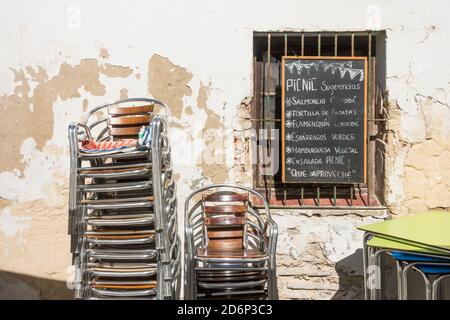 Gestapelte Stühle im geschlossenen spanischen Restaurant wegen Einschränkungen in Corona Crisis, Tarifa, Spanien. Stockfoto