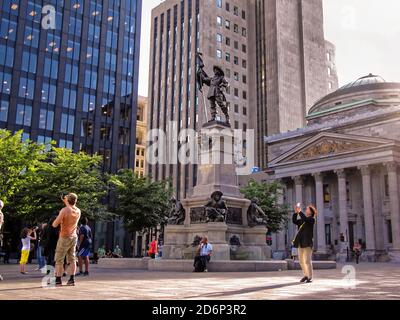 MONTREAL, KANADA - 06 24 2016: Das Maisonneuve Monument vor dem Aldred Building im Herzen von Montreal. Es ist ein Denkmal in Erinnerung an Paul Chomedey Stockfoto