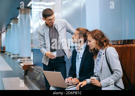 Junge Geschäftsleute diskutieren Arbeitsfragen auf der U-Bahn-Plattform . Stockfoto