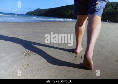 Mann beim Spaziergang am Strand von Etty Bay, in der Nähe von Innisfail, Queensland, Australien. Nein, MR Stockfoto