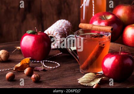 Heißer Apfelmost mit Zimtstangen, Nelken und Anis auf Holzgrund. Traditionelle Herbstgetränke, Wintergetränke und Cocktails Stockfoto