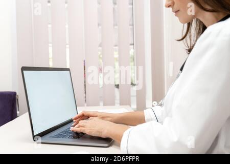 Nahaufnahme einer Ärztin mit Laptop-Computer und Mockup. Stockfoto