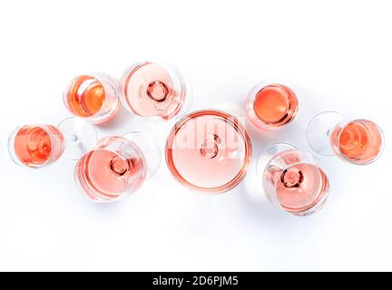 Roséweingläser bei Weinprobe. Degustation verschiedene Sorten von rosa Wein Konzept. Weißer Hintergrund, Draufsicht, hartes Licht Stockfoto