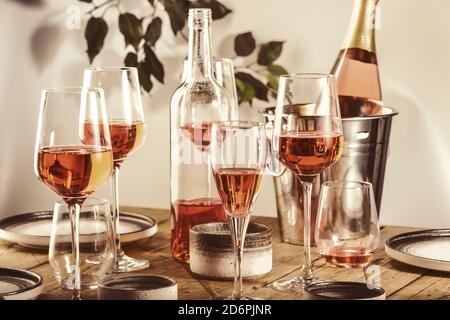 Roséwein Gläser und Flaschen auf dem Tisch serviert für festliche Dinner Party mit verschiedenen Arten von Vorspeisen und Obst Stockfoto