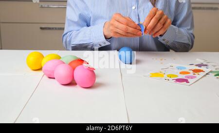 Weibliche Hände schmücken Ostereier mit Vogel-förmigen Dekor. Ostereier in Pastellfarben Nahaufnahme, Kopierraum Stockfoto