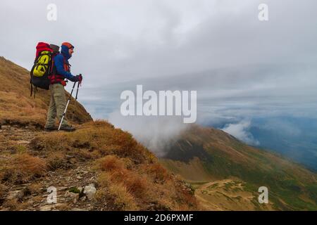 Wanderer mit Rucksack und andere Ausrüstung auf der Bergspitze. Urlaub in den Bergen. Stockfoto