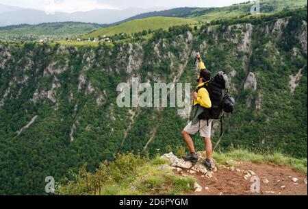 Wanderer mit Rucksäcken erreicht den Gipfel des Berggipfels. Erfolg, Freiheit und Glück Konzept Stockfoto