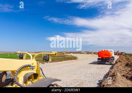 Transform-Landschaft ins Stadtgebiet mit Maschinen, arbeiten Menschen. Blick auf die Baustelle. Stockfoto