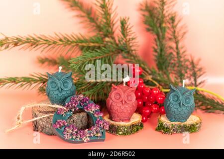 Handgemachte Honigkerzen aus Naturwachs in Form von Eulen auf rosa Hintergrund. Elemente aus natürlichen Materialien. Weihnachten oder Neujahr Stockfoto