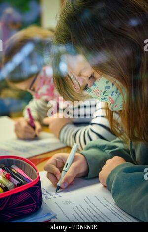 Kiel, Deutschland. Oktober 2020. Schülerinnen und Schüler einer sechsten Klasse der Max-Planck-Schule in Kiel schreiben in der ersten Unterrichtsstunde nach den Herbstferien etwas in ihre Notizbücher. Quelle: Gregor Fischer/dpa/Alamy Live News Stockfoto