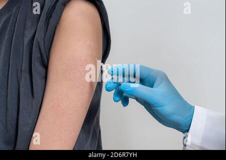 Der Arzt injiziert männliche Patienten. In der Hand des Arzters haben Spritzen. Stockfoto