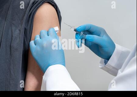 Der Arzt injiziert männliche Patienten. In der Hand des Arzters haben Spritzen. Stockfoto