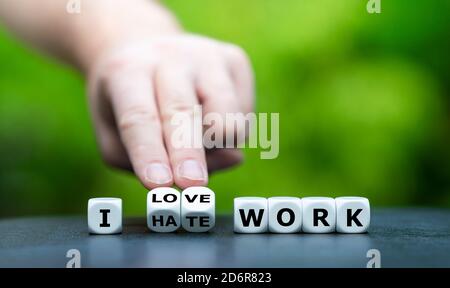 Hand dreht Würfel und ändert den Ausdruck "Ich hasse Arbeit" zu "Ilove Arbeit". Stockfoto