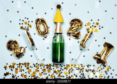 Champagner-Flasche und 2021 Ballons mit schwarzen und goldenen Sternen Stockfoto