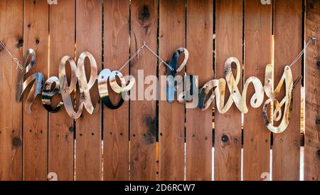 Wörter HELLO BABY aus goldener Folie auf Holzhintergrund. Babydusche, Geburtstagsfeier feiert Dekoration. Stockfoto