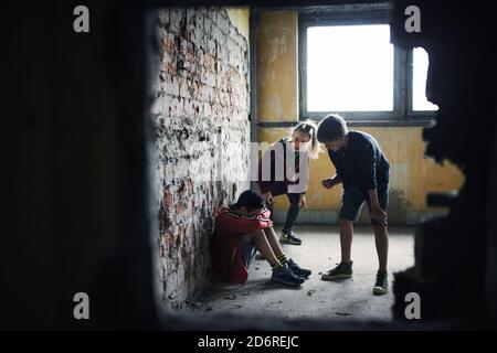 Teenager Junge von Schlägern in verlassenen Gebäude, Bandengewalt und Mobbing Konzept angegriffen. Stockfoto