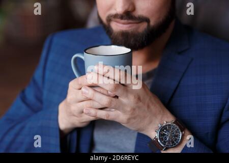 Nahaufnahme von jungen lächelnden Geschäftsmann in formeller Kleidung halten Tasse, Tasse Kaffee Stockfoto
