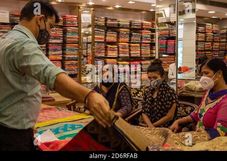 Dehradun, Uttarakhand/Indien-Oktober 14 2020:EIN Mädchen sieht Saree für ihre Ehe mit zwei Damen Waring Gesichtsmaske, wegen Korona Pandemie in Indien. . Hochwertige Fotos Stockfoto