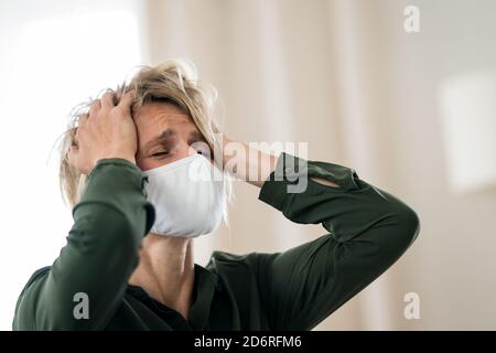 Frustrierte Frau drinnen zu Hause Gefühl gestresst, psychische Gesundheit und Coronavirus Konzept. Stockfoto