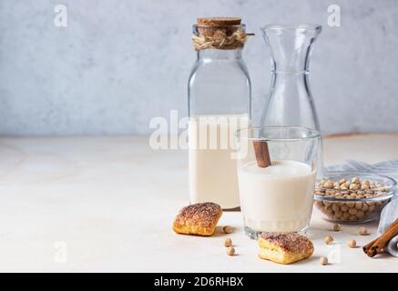 Kichererbsen vegetarische Milch in einer Flasche und Glas und rohe Kichererbsen auf hellem Hintergrund. Laktosefreie nicht-Milchprodukte. Gesundes veganes Lebensmittelkonzept. Stockfoto