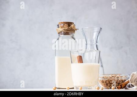 Kichererbsen vegetarische Milch in einer Flasche und Glas und rohe Kichererbsen auf hellem Hintergrund. Laktosefreie nicht-Milchprodukte. Gesundes veganes Lebensmittelkonzept. Stockfoto