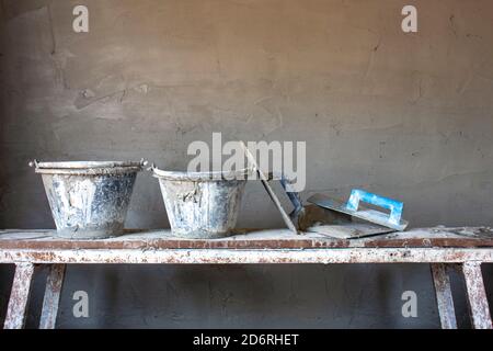 Ausrüstung für den Bau von Zementwänden, die auf Holzbohlen auf der Baustelle platziert werden, einschließlich unfertiger Zementwände. Stockfoto