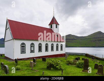 Die Insel Kunoy mit Dorf Kunoy und Kirche. Im Hintergrund die Insel Kalsoy. Nordoyggjar (Nördliche Inseln) auf den Färöern, ein Archipel Stockfoto