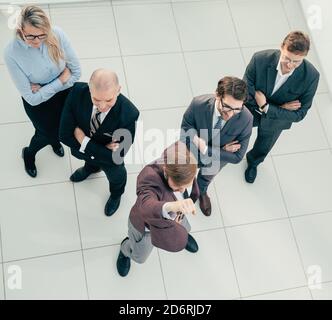 Draufsicht. Anführer und eine Gruppe von Mitarbeitern stehen zusammen. Stockfoto
