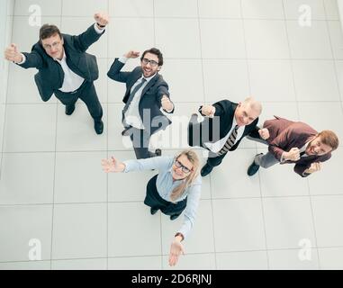 Draufsicht. Lustiges Business-Team beim Blick auf die Kamera. Stockfoto