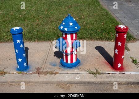 Ein Hydrant und angrenzende Stangen sind mit einem ptriotischen Motiv verziert. In Whitestone, Queens, New York City.A Stockfoto