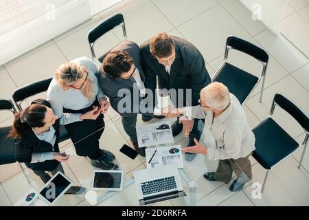 Draufsicht. Kollegen aus der Wirtschaft schütteln sich im Einvernehmen die Hände. Stockfoto