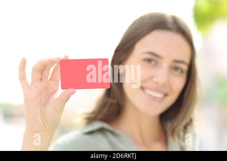 Eine glückliche Frau, die draußen auf der Straße eine leere Kreditkarte zeigte Stockfoto