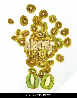 Frische Kiwi und getrocknete Kiwi-Scheiben auf weißem Hintergrund. Stockfoto