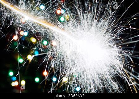 Bengal Licht Blitz auf Hintergrund weihnachtsbaum mit Girlande Lichter. Abstrakter unscharfer Hintergrund Stockfoto