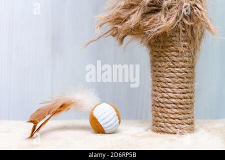 Gebrauchte Katze Kratzpfosten und Katze Spielzeug Ball mit Federn Auf weißem Hintergrund Stockfoto