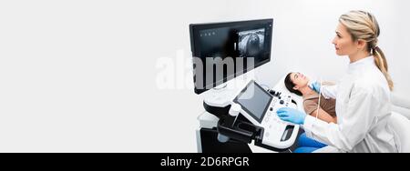 Ultraschalldiagnostik der Schilddrüse. Eine Endokrinologin, die einer Patientin in einem Ultraschallbüro eines modernen clin Ultraschalluntersuchungen anstellt Stockfoto