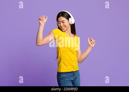Fröhliche Asiatische Frau Musik Hören Und Tanzen Mit Geschlossenen Augen Stockfoto